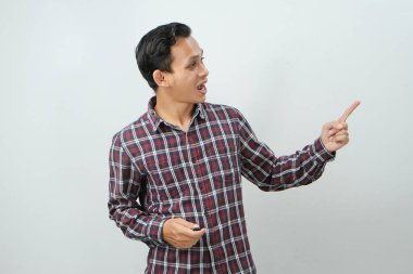 Mutlu Asyalı Endonezyalı adam izole edilmiş arka planda parmak işareti yapıyor.