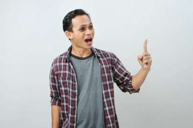 Mutlu Asyalı Endonezyalı adam izole edilmiş arka planda parmak işareti yapıyor.