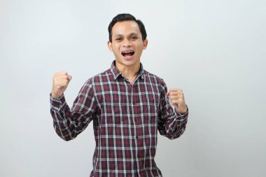Mutlu Asyalı Endonezyalı adam, izole edilmiş arka planda baş parmak hareketi yapıyor.