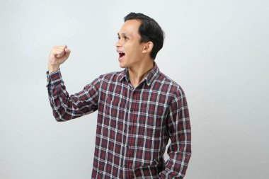 Mutlu Asyalı Endonezyalı adam, izole edilmiş arka planda baş parmak hareketi yapıyor.