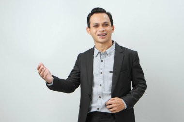 Mutlu, kendine güvenen Endonezyalı, takım elbiseli iş adamı izole edilmiş arka planda el hareketi yapıyor.