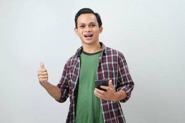 Akıllı telefon tutan mutlu Asyalı Endonezyalı adam. izole edilmiş arkaplanda