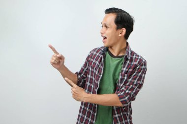 Mutlu Asyalı Endonezyalı adam izole edilmiş arka planda parmak işareti yapıyor.