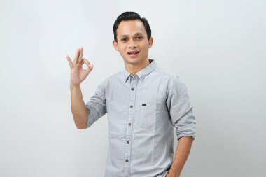 Neşeli, mutlu, kendine güvenen Endonezyalı, izole edilmiş arka planda parmak hareketi yapan.