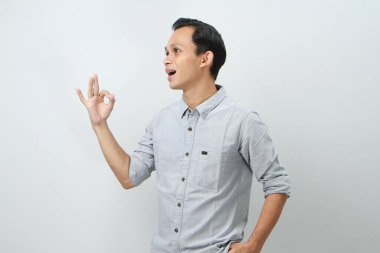 Neşeli, mutlu, kendine güvenen Endonezyalı, izole edilmiş arka planda parmak hareketi yapan.
