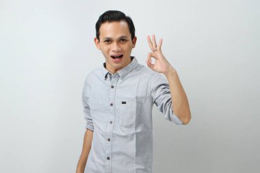 Neşeli, mutlu, kendine güvenen Endonezyalı, izole edilmiş arka planda parmak hareketi yapan.