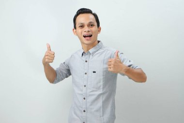 Neşeli, mutlu, kendinden emin Endonezyalı, parmak kaldıran, izole edilmiş bir geçmişi olan bir adam.
