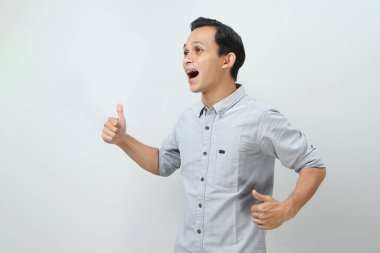 Neşeli, mutlu, kendinden emin Endonezyalı, parmak kaldıran, izole edilmiş bir geçmişi olan bir adam.