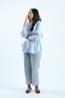 Asyalı Endonezyalı kadının, izole edilmiş arka planda şok olmuş yüz ifadesiyle uzun bir çekim.