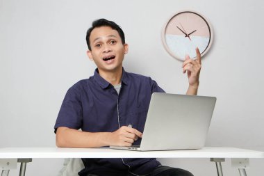 İş yerinde dizüstü bilgisayarın önünde oturan neşeli, mutlu Asyalı adam. izole edilmiş arkaplanda