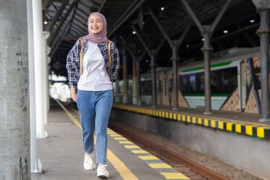 Asyalı Müslüman kadının tren istasyonunda uyandığı uzun bir çekim. seyahat kavramı