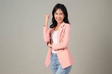 Coşkulu Asyalı kadın seviniyor, evet diyor, mutlu görünüyor ve zaferi kutluyor, şampiyon dansı, yumruk tokuşturma hareketi, mutlu Asyalı kadınlar izole arka planda yumruğunu şaklatıyor.