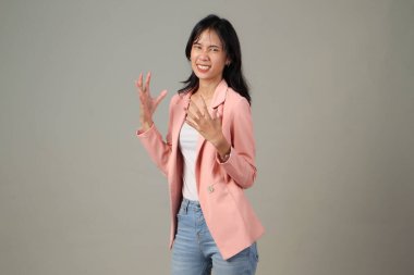 Asyalı bir kadının izole edilmiş arka planda günlük kıyafet giymesi stresli bir kızgınlık ifadesi.