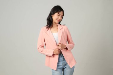 Asyalı mutlu iş kadını izole edilmiş arka planda resmi giyiniyor.