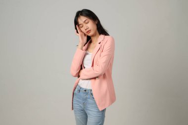 Soyutlanmış arka planda resmi kıyafet giyen düşünceli Asyalı kadın.