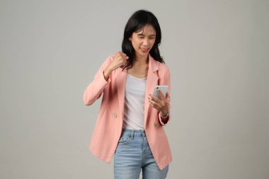 Kızgın Asyalı kadın izole edilmiş arka planda cep telefonu tutuyor.