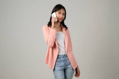 Mutlu Asyalı kadın telefonda konuşuyor. Yüzünde heyecanlı bir ifade var.