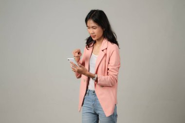 Kızgın Asyalı kadın izole edilmiş arka planda cep telefonu tutuyor.