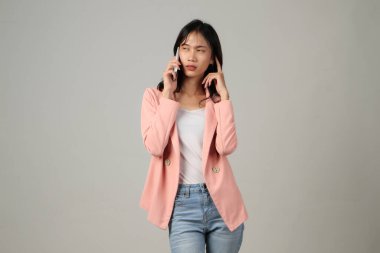 Düşünceli Asyalı kadın telefonda konuşuyor. Yüzünde endişeli bir ifade var.