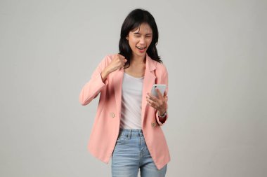 Kızgın Asyalı kadın izole edilmiş arka planda cep telefonu tutuyor.