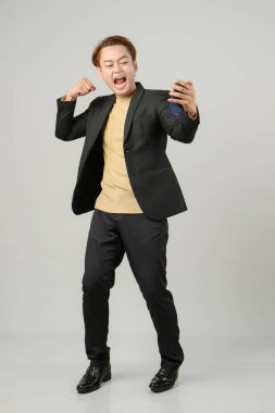 Neşeli, mutlu Asyalı iş adamının cep telefonuyla çektiği uzun bir çekim.