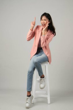 Mutlu, heyecanlı Asyalı bir kadının el pençe divan durup arka planda el pençe divan durarak bağırdığı uzun bir çekim.