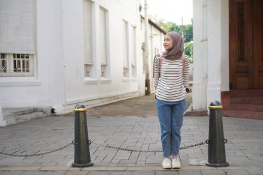 asian muslim woman on the street at Kota Lama or Old Town City, Semarang, Indonesia  clipart