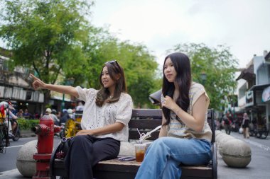 Malioboro caddesinde oturan iki genç Asyalı kadın, Yogyakarta, Endonezya