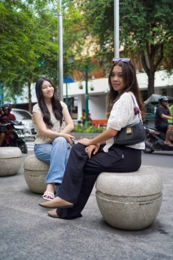 Malioboro caddesinde oturan iki genç Asyalı kadın, Yogyakarta, Endonezya