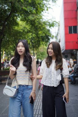 Mutlu iki Asyalı kadın Malioboro caddesinde yürüyor, Yogyakarta, Endonezya
