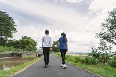 Kırsal bölgede etkin Asyalı çiftlerin yürüyüş egzersizlerinin arka görüntüsü