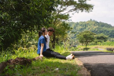 Aktif Asyalı genç çift kırsal alanda egzersize ara veriyor.