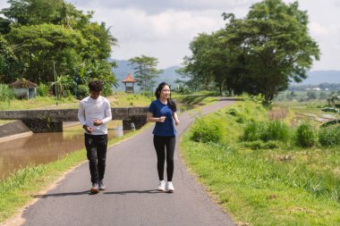 aktif Asyalı genç çift kırsal alanda koşuyor ve koşuyor