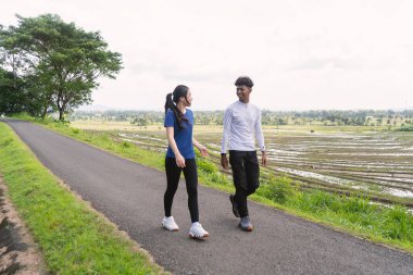 aktif genç Asyalı çift kırsal alanda yürüyüş egzersizi yapıyor.