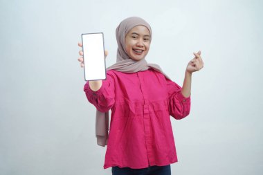 Boş Ekran ile Akıllı Telefon Gösteren Mutlu Asyalı Kadın ve İzole edilmiş Arkaplanda Parmak Kalbini Yapan Jest