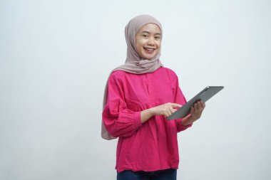 Tesettürde gülümseyen Müslüman Kadın Beyaz Arkaplanda izole edilmiş dijital tablet kullanıyor