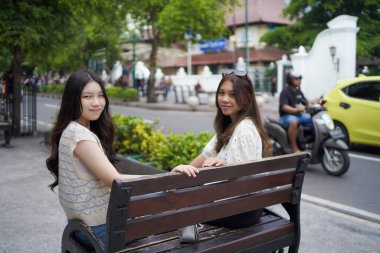 Malioboro caddesinde oturan iki genç Asyalı kadın, Yogyakarta, Endonezya