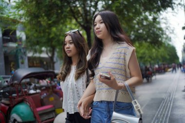 Mutlu iki Asyalı kadın Malioboro caddesinde yürüyor, Yogyakarta, Endonezya
