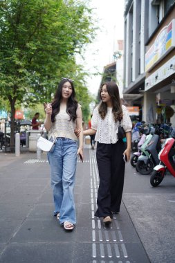 Mutlu iki Asyalı kadın Malioboro caddesinde yürüyor, Yogyakarta, Endonezya