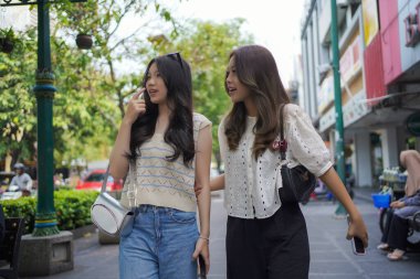 Mutlu iki Asyalı kadın Malioboro caddesinde yürüyor, Yogyakarta, Endonezya