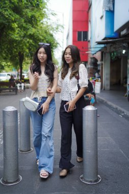 Mutlu iki Asyalı kadın Malioboro caddesinde yürüyor, Yogyakarta, Endonezya