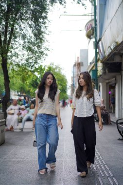 Mutlu iki Asyalı kadın Malioboro caddesinde yürüyor, Yogyakarta, Endonezya