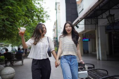 Mutlu iki Asyalı kadın Malioboro caddesinde yürüyor, Yogyakarta, Endonezya