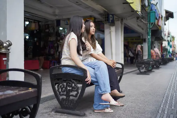 Malioboro caddesinde oturan iki genç Asyalı kadın, Yogyakarta, Endonezya