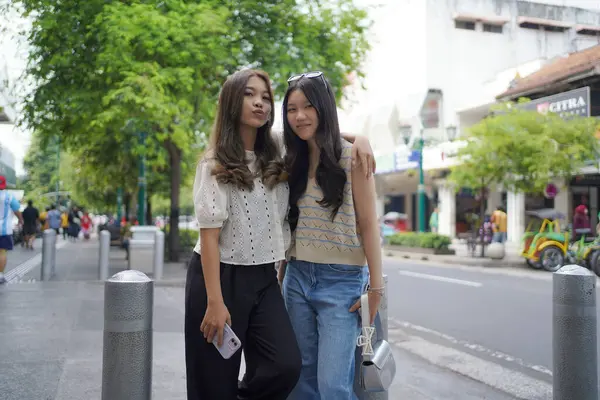 İki genç Asyalı kadın Malioboro caddesinde duruyor, Yogyakarta, Endonezya