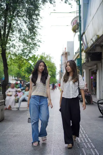 Mutlu iki Asyalı kadın Malioboro caddesinde yürüyor, Yogyakarta, Endonezya