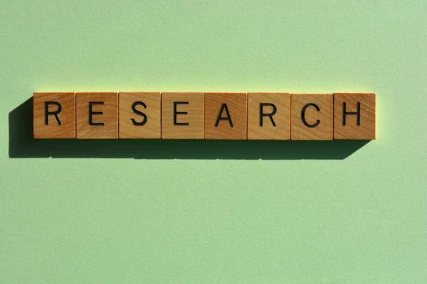 Research, word in wooden alphabet letters isolated on green background