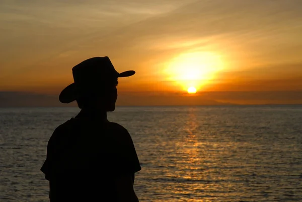 Silhouette of person watching the sunset over the sea and horizon, West Point, Magnetic Island