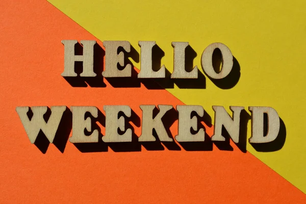 Hello Weekend, words in wooden alphabet letters isolated on bright and colourful background