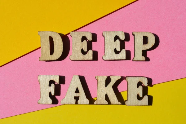 ディープフェイク ピンクと黄色の背景に隔離された木製のアルファベットの言葉 — ストック写真